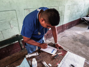 A physician charts on paper cards on a medical service trip in rural Guatemala